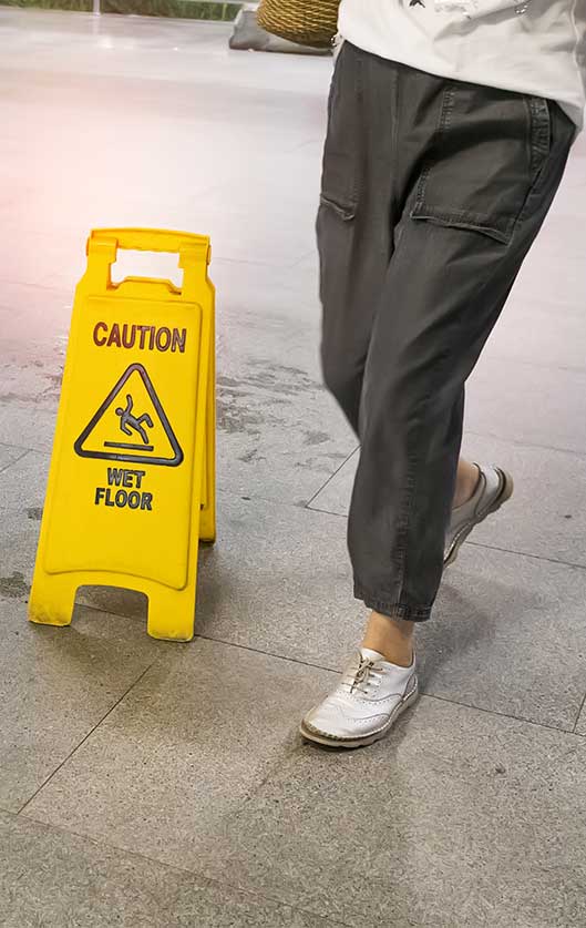A person walking near a caution sign.